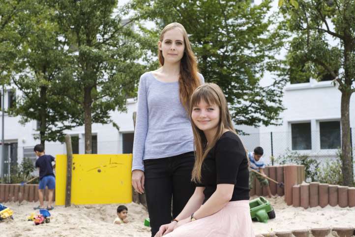 Zwei junge Frauen sitzen auf einem Spielplatz