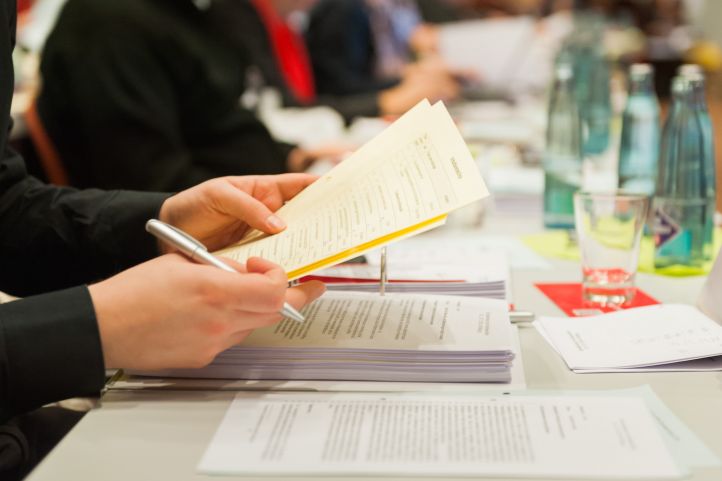 Bild zeigt eine Delegierte der Bundeskonferenz 2016 beim Lesen der Anträge