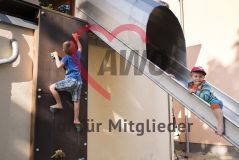 zwei Kinder spielen an Kletterwand - ein Junge guckt in die Kamera