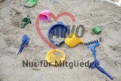 Spielzeuge liegen im Sandkasten