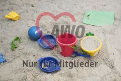 Spielzeuge Eimer Siebe Gießkanne Ball liegen im Sandkasten
