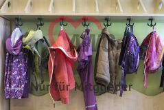 Taschen und Kleidung hängen an einer Garderobe