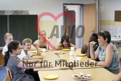 Mehrere Kinder Mädchen und Jungen sitzen in einem Klassenzimmer und essen