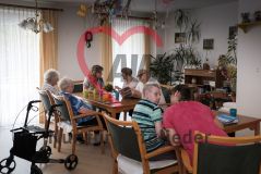 Mehrere alte Frauen und Männer Seniorinnen und Senioren sitzen in einem Aufenthaltsraum