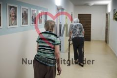 Zwei alte Frauen Seniorinnen laufen in einem Flur einer Pflegeeinrichtung