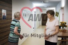 Zwei alte Frauen Seniorinnen stehen sich im Gang eines Pflegeheims