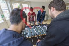 Vier Männer spielen konzentriert an einem Kickertisch