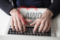 Hände eines Mannes, die auf einem Laptop Macbook tippen