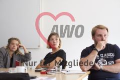 Zwei junge Frauen und ein junger Mann sitzen an einem Arbeitstisch Workshop Seminar
