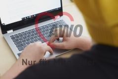 Eine Person mit Mütze arbeitet an einem Laptop Notebook Rechner
