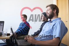 Mehrere junge Männer mit Laptop Notebook Rechner sitzen in einem Workshop Seminar