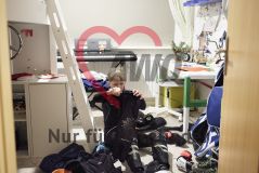 Junge zieht im Kinderzimmer Sportkleidung an
