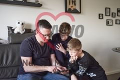 Vater und zwei Söhne mit Smartphone/Handy