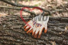 Kinderhandschuhe auf einem Baumstamm im Wald